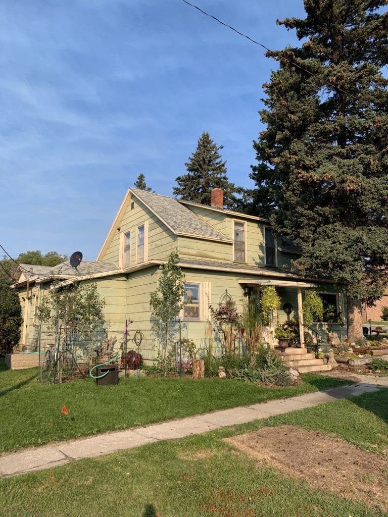 house with siding damaged by hail and storms before siding is replaced